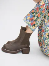 Bota tipo chelsea de cuero vacuno en color rojo con estampado floral grabado en negro. Presenta paneles laterales elásticos, suela de plataforma y taco cuadrado en color negro.