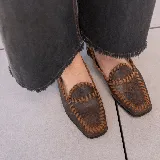 Mocasines marrones de cuero con punta cuadrada y detalle de costuras en color beige.