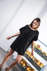 Vestido corto de tejido calado color marrón, con patrón cuadrado y logo bordado a mano en el frente. Presenta terminaciones a contratono en escote redondo y mangas cortas.