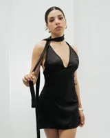 Vestido corto de seda color negro, con escote pronunciado en V y detalle de cuello tipo choker integrado con lazo largo lateral.