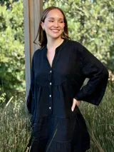 Vestido amplio de lino color verde lima, con cuello mao y abertura frontal con botones de coco. Presenta un diseño con canesú fruncido y volados en los puños de las mangas largas.