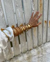 Pulsera tipo esclava abierta con diseño rústico y acabado irregular, fabricada en bronce y alpaca.