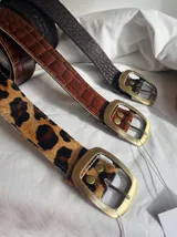 Cinto de cuero con hebilla metálica dorada.