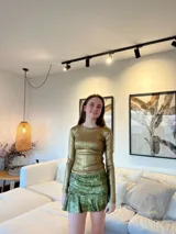 Pollera corta con volado en el ruedo, confeccionada en tela con lentejuelas doradas.