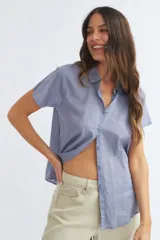 Camisa celeste de manga corta con cuello clásico y cierre con botones.