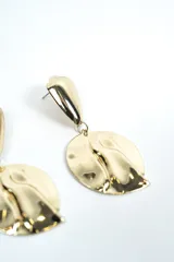 Aros colgantes plateados de diseño orgánico y acabado brillante, compuestos por una pieza superior geométrica y un dije circular con relieve ondulado.