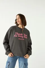 Buzo gris oscuro de algodón y poliéster con calce amplio y estampa frontal en color rosa con relieve.