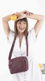 Bandolera color beige de símil cuero, con cierre principal, bolsillos interiores, bolsillo frontal y posterior con cierres, y bolsillos laterales. Incluye correa extensible.