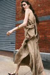 Falda midi de tiro alto y diseño asimétrico con cierre frontal cruzado y botón decorativo. Presenta una textura rústica con estampado sutil y forro interior marrón.