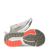 Championes de running New Balance modelo Nitrel, color gris con detalles en naranja y suela con tecnología AT Tread. Presenta diseño de malla transpirable y refuerzo Toe Protect en la puntera.