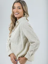 Camisa color crema con bordados florales, de corte recto y mangas largas.
