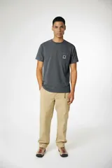 Remera de manga corta color verde menta con cuello redondo y un bolsillo en el pecho con un parche cuadrado azul con una 'X' blanca.