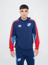 Canguro deportivo Umbro del Club Nacional de Football, modelo Nexo para hombre. Diseño en color azul marino con mangas rojas y detalles en celeste y blanco, capucha con cordón ajustable y bolsillo tipo canguro.