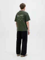 Remera verde militar de manga corta, con cuello redondo y diseño holgado. Cuenta con un pequeño estampado tipográfico en el pecho.