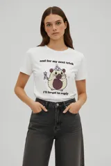 Remera de algodón de manga corta y cuello redondo, con corte holgado y estampado frontal de un hámster con gorro de fiesta y varita mágica, acompañado de la frase 'and for my next trick i'll forget to reply'.