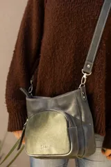 Cartera compacta de cuero color marrón, con diseño versátil y atemporal. Cuenta con un bolsillo exterior de gamuza con cierre y correa regulable con mosquetones metálicos.