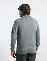 Sweater de punto color tostado, con cuello alto y cierre frontal parcial con botones. Diseño de manga larga con puños y ruedo acanalados.