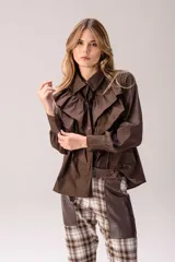 Camisa blanca de corte clásico con volados frontales y en los hombros, manga larga con puños abotonados y cierre frontal con botones.