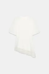 Camiseta de algodón compacto con cuello redondo y manga corta. Presenta un diseño de bajo asimétrico con aplicación de encaje a tono.