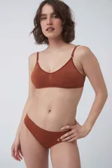 Soutien tipo bralette color beige, sin costuras y sin aro, con copas removibles. Confeccionado en microfibra, tiene breteles regulables y broche doble en la espalda con tres medidas.