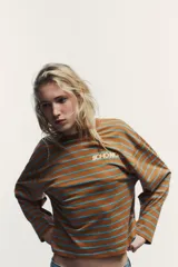 Camiseta marrón a rayas horizontales celestes, de manga larga y cuello redondo. Estampado frontal con la palabra 'SOHONOHO' en blanco.