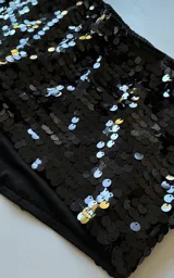 Mini short negro completamente cubierto de lentejuelas brillantes, de tiro medio y calce ajustado.