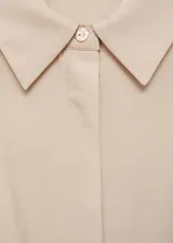Vestido midi de diseño recto y cuello camisero, sin mangas con hombros estructurados. Confeccionado en una mezcla de lyocell y lino, presenta cierre frontal con botones y aberturas laterales en el bajo. Incluye un cinturón ajustable de efecto cuero.