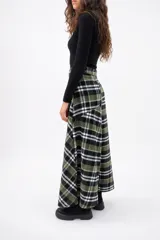 Falda midi de corte evasé con estampado de cuadros escoceses en tonos blanco y negro. Presenta un diseño con cortes asimétricos y cierre lateral.