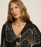 Blusa negra con estampado de hojas en color crema, escote en V y mangas 7/8.