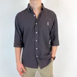 Camisa lisa de algodón color borra vino, con cuello italiano, mangas largas y corte clásico. Presenta un pequeño logo bordado en el pecho.