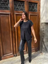 Blusa de lurex color negro con tajo en la parte delantera y mangas cortas.