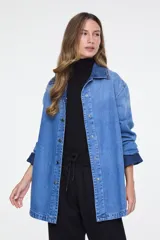 Camisa oversize de denim azul claro, con cuello clásico, mangas largas y cierre frontal de broches metálicos.