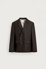 Blazer cruzada de hombre en color marrón oscuro, de corte regular fit, confeccionada en lino. Cuenta con solapas de muesca, bolsillos con solapa en la cadera y doble botonadura frontal.