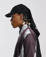 Gorra con visera curva y sistema de ajuste trasero. Incluye pañuelo integrado de seda con estampado abstracto en tonos grises y blancos.