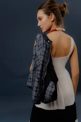 Campera de denim azul con detalles de tela en cuadrillé gris y azul, cierre frontal metálico y mangas largas.