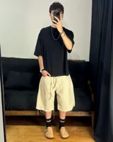 Bermuda de corte baggy color beige crema, con costura vertical trasera en cada pierna y detalle artesanal visible en el bajo. Incluye un cordón extra confeccionado en la misma tela.