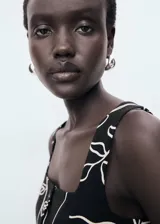 Top sin mangas de tejido mezcla de lino, con cuello escotado y cierre frontal de tres botones. Presenta un diseño entallado con estampado floral en contraste y dos bolsillos de ribete frontales.