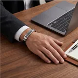 Pulsera masculina con diseño moderno, compuesta por una placa central de acero inoxidable con detalles calados y bandas laterales de goma negra.
