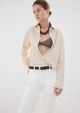 Jeans blancos de tiro alto y estilo flare, confeccionados en tejido elástico de algodón. Presentan diseño de cinco bolsillos, trabillas para cinturón y cierre frontal con cremallera y botón.