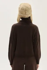 Polera de tejido de punto color azul, con cuello alto, manga larga y puños acanalados.