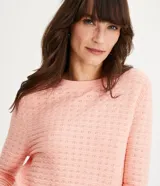 Blusa de punto color celeste con textura ondulada, cuello redondo y mangas largas.