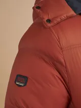 Campera puffer verde militar con capucha, cierre frontal, bolsillos laterales con cierre y un bolsillo de solapa en el pecho.