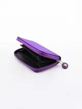 Billetera pequeña de diseño compacto en color violeta, con cierre perimetral y logo circular grabado en el frente.