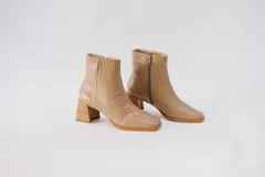 Botas plateadas de cuero con caña media, cierre lateral con cremallera, punta cuadrada y tacón geométrico de madera.