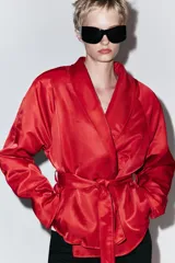 Cazadora corta de Zara color rojo, con cuello smoking, manga larga y cinturón ajustable del mismo tejido.