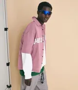 Camisa de corte oversized confeccionada en algodón, con estampado de cuadros tipo pied de poule en color rojo y blanco. Presenta cuello inglés, cierre frontal con botones y estampado lettering Breakout en el frente.