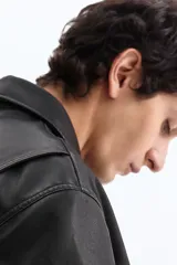 Campera negra de tejido revestido con cuello, cierre frontal y bolsillos laterales. Cuenta con puños y bajo con elástico revestido.