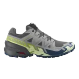 Championes de trail running Salomon Speedcross 6, color gris con detalles en verde lima y azul, con sistema de ajuste rápido Quicklace y suela Contagrip de gran tracción.