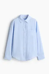 Camisa de manga larga en tejido liviano de mezcla de lino y viscosa, color celeste, con cuello clásico, cierre frontal de botones, bolsillo superior en el pecho y bajo redondeado.