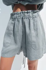 Shorts de tiro medio confeccionados en 100% lino, con cintura elástica ajustable mediante cordones y bolsillos delanteros.